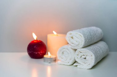 Spa konsept fotoğrafında doğal sağlık. Beyaz havlular ve mum ışıkları..