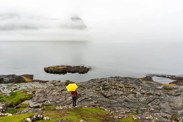 Kobieta Podróżująca Żółtym Parasolem Fiordem Górami Pokrytymi Gęstą Mgłą Wyspy — Zdjęcie stockowe