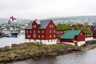 Kırmızı parlaklık binası ve Faroe bayrağı ile Torshavn Limanı.