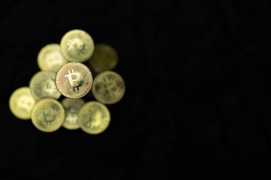 Siyah zemin üzerinde altın bitcoin yığını ve sağ tarafında fotokopi alanı. Kripto para birimi konsepti fotoğrafı.