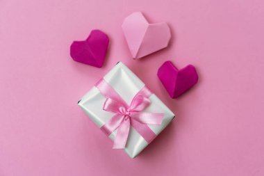 Origami kalpleri ve pembe kurdeleyle sarılmış bir hediye kutusu..