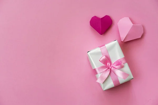 情人节浪漫的平房照片 配有礼品盒和彩带 背景为粉色的折纸心形 — 图库照片