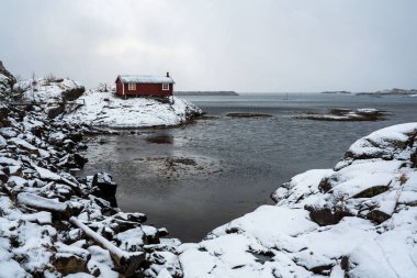Fiyorttaki kırmızı balıkçının evi, kış manzarası. Lofoten Adaları, Norveç.