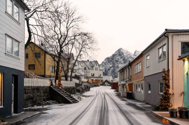 Noel tatilinden sonra boş köy sokağı, yol ve taze karla kaplı evler. Henningsvaer, Lofoten Adaları.