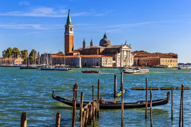 Venedik, İtalya - 26 Eylül 2018: San Giorgio Maggiore adası ve Katedrali Saint Mark Meydanı yakınlarındaki rıhtımdan görülüyor. Ön planda gondolcusu ve turisti olan bir gondol var..