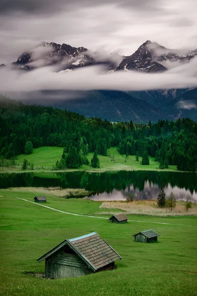 Lago Geroldsee durante el día lluvioso de verano, Alpes bávaros, Baviera, Alemania. Hermoso movimiento de nubes pesadas sobre montañas masivas y segadoras . — Foto de Stock