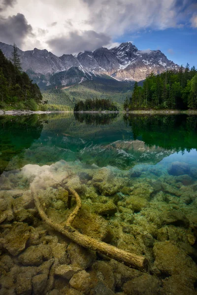 Belo reflexo do pico mais alto da montanha Zugspitze no lago Eibsee e incríveis nuvens tempestuosas, Baviera, Alemanha . — Fotografia de Stock