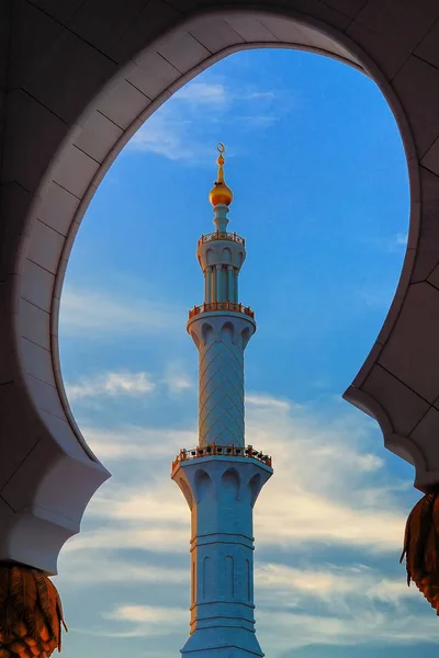 De minaret van de moskee, Abu Dhabi, Verenigde Arabische Emiraten. Typische avondrood met kleurrijke wolken — Stockfoto