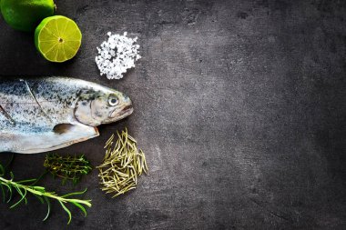 Kireç ve baharat ile taze alabalık. Koyu arka plan balık. Ayrıntılı hazırlık