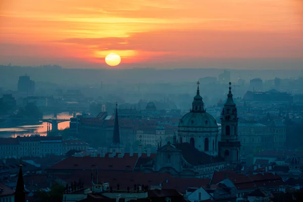 Wschód słońca za wieżą kościoła św Mikołaja, Praga, Czech re — Zdjęcie stockowe