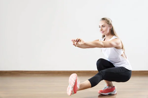 Genç kadın çalışmaları fitness sınıfta yerleştirmek.