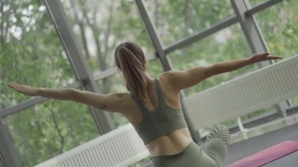 Mujer atlética joven practicando yoga. Vista trasera. Movimiento de la cámara giratoria . — Vídeos de Stock