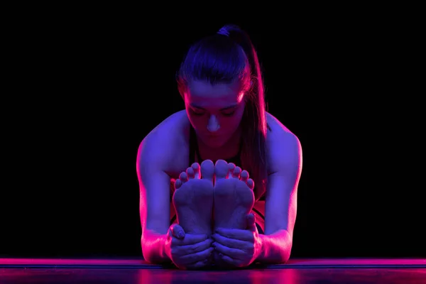 Młoda, sprawna kobieta ćwicząca jogę. Neonowe światło. Nowoczesna sci fi reprezentacja jogi. Spokojna atmosfera. Przestrzeń kopiowania. — Zdjęcie stockowe