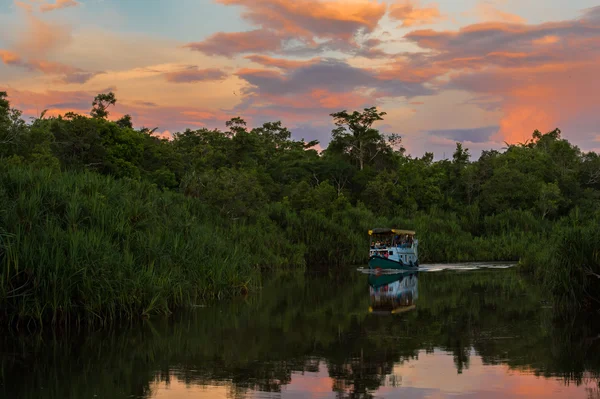 Iate azul navega sob as nuvens coloridas (Kumai, Indonésia ) — Fotografia de Stock