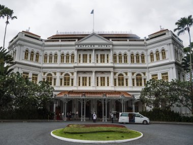 Beyaz ve parlak Raffles hotel ve yeşil çiçek yatak önünde (Singapur)