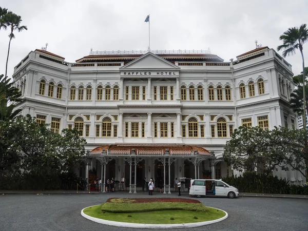 Beyaz ve parlak Raffles hotel ve yeşil çiçek yatak önünde (Singapur)