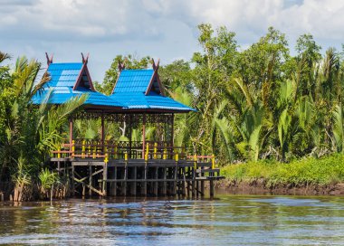 Askılar standları (Kumai Nehri yakınındaki mavi bir çatı ile küçük ev)