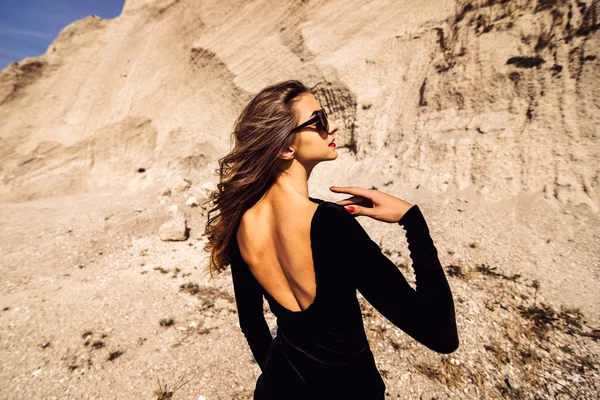 Красива жінка в довгій чорній сукні, що йде на відкритому повітрі — стокове фото