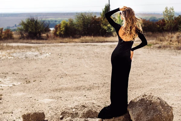 Mujer bonita en vestido largo negro caminando al aire libre — Foto de Stock