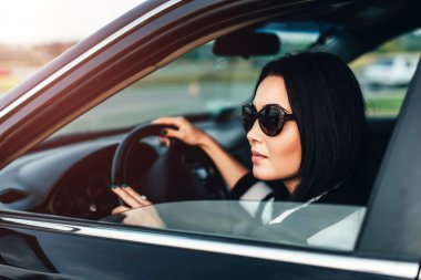 Araba süren genç bir kadın.