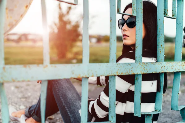 フェンスの後ろに座っていた若い女性 — ストック写真