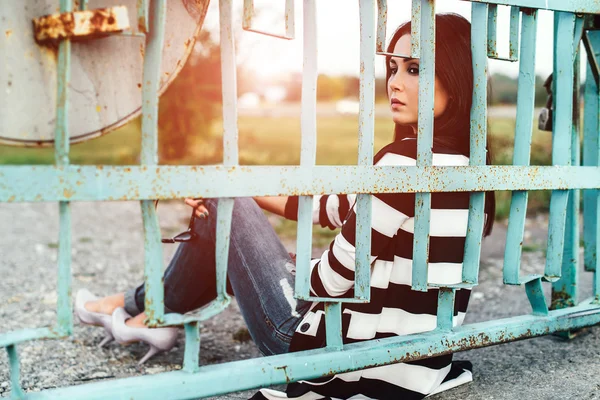 Young woman sitting behind fence — Stock Photo, Image