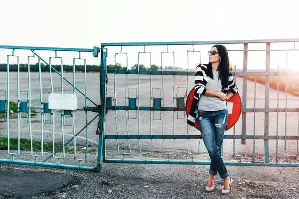 Young woman standing near old fence — Stock Photo, Image