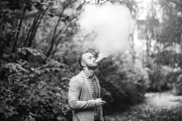 Pria dengan jenggot merokok rokok elektronik — Stok Foto