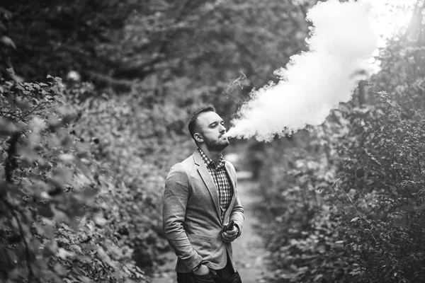 Pria dengan jenggot merokok rokok elektronik — Stok Foto