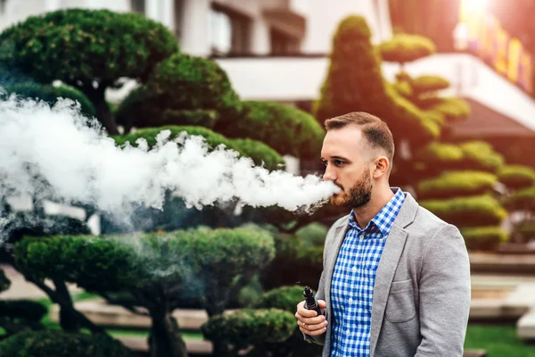 Man with beard vaping electronic cigarette — Stock Photo, Image