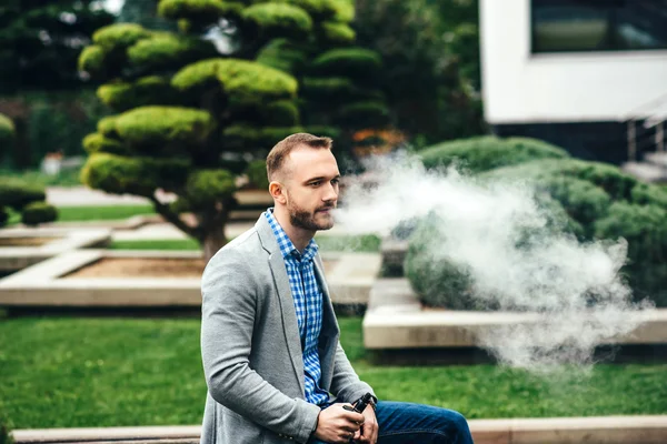 Uomo con barba vaporizzante sigaretta elettronica — Foto Stock