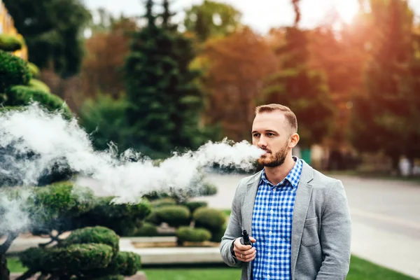 Uomo con barba vaporizzante sigaretta elettronica — Foto Stock