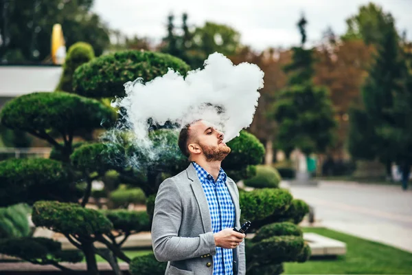 Uomo con barba vaporizzante sigaretta elettronica — Foto Stock