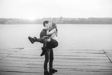 Kız arkadaşı kollarında tutan genç çocuk