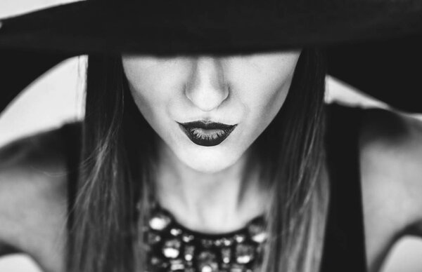 Portrait of pretty girl in black hat outdoor, black and white photo