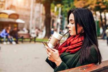 kahve ve telefon ile oturan kız
