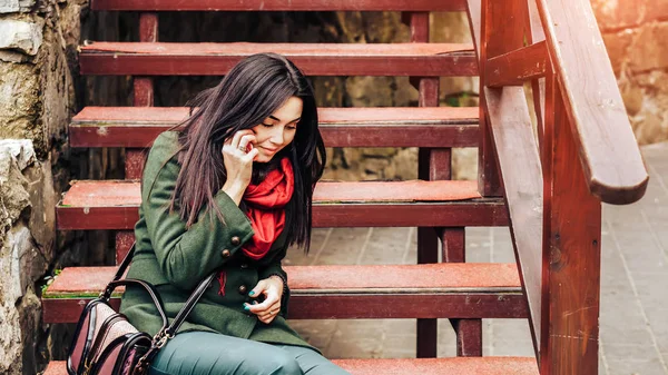 Flicka sitter på trappan med telefon — Stockfoto