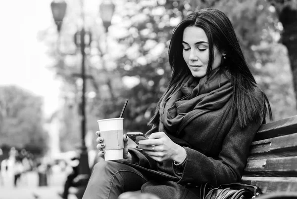 Chica sentada con café y teléfono — Foto de Stock
