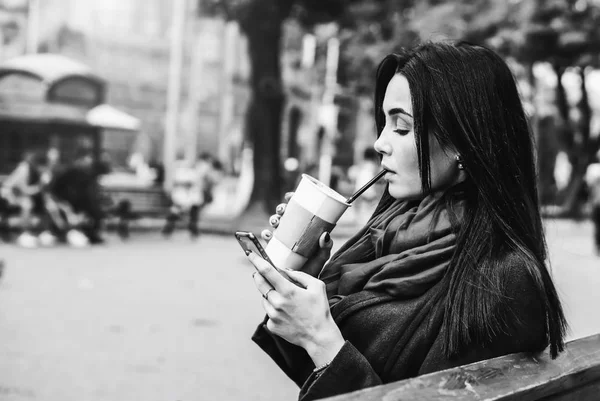 Meisje zittend met koffie en telefoon — Stockfoto