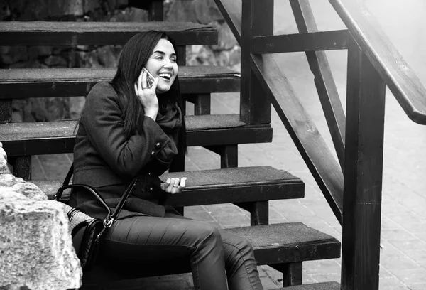 Meisje zittend op de trap met telefoon — Stockfoto