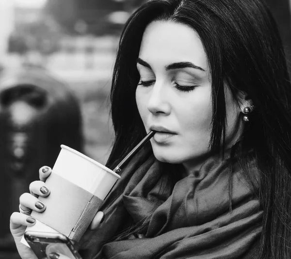 Flickan sitter med kaffe och telefon — Stockfoto