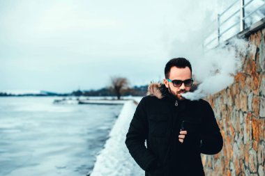 Adam elektronik sigara içiyor.