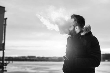 Adam elektronik sigara içiyor.