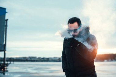 Adam elektronik sigara içiyor.