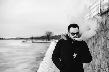 Adam elektronik sigara içiyor.