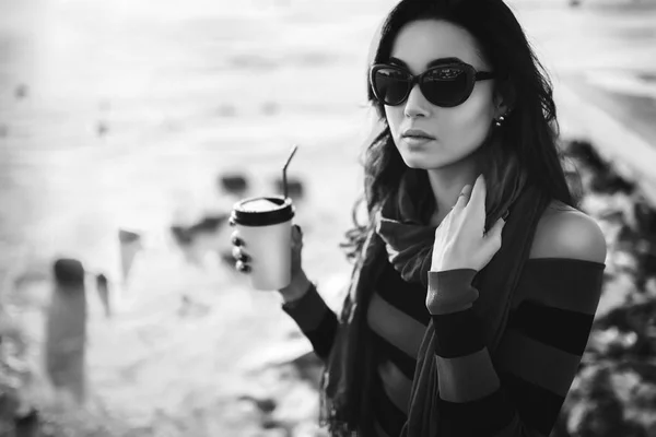 Брюнетка ходить на открытом воздухе в парке с чашкой кофе — стоковое фото