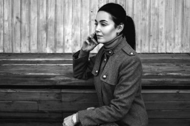 smartphone ile bankta oturan kadın