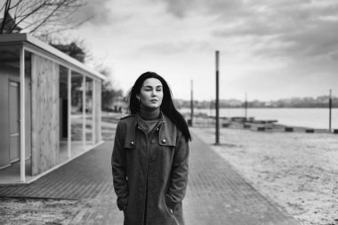 Genç bir kadın parkta yürüyor.