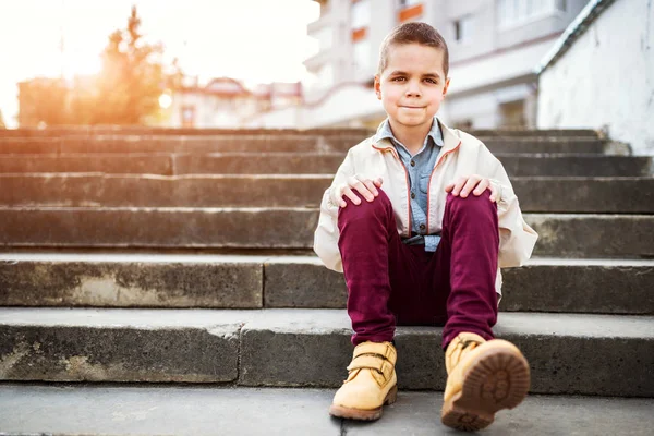 Pojken sitter på trappan — Stockfoto