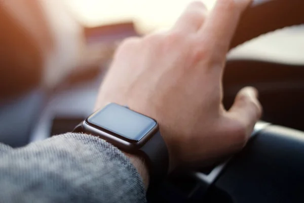 man driving a car with smart watch